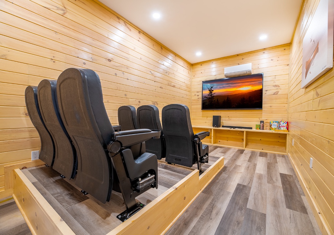 Your private theater features plush reclining seats and rustic wood walls, creating the perfect cozy retreat for movie nights.