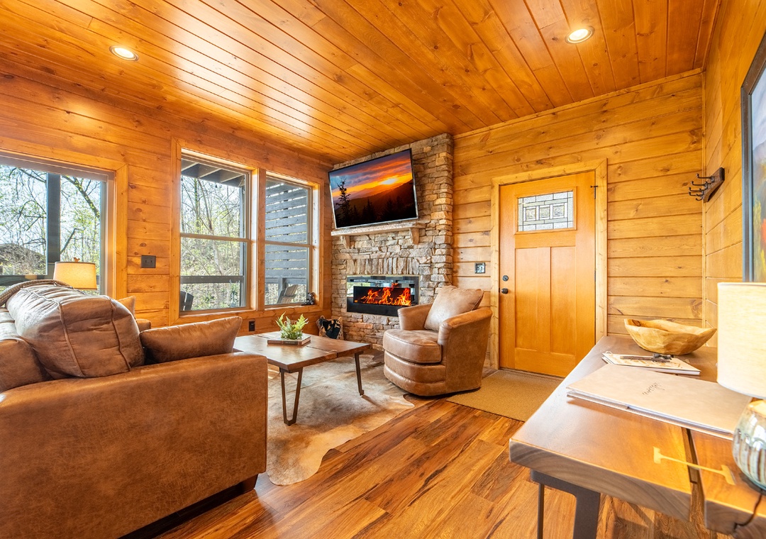 Unwind in your cozy living room where warm wood surrounds you and the crackling fireplace creates perfect ambiance for relaxing evenings.