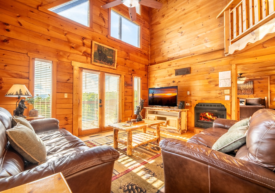 Sink into plush leather sofas by your crackling fireplace, where soaring ceilings and warm wood surround you in cozy mountain luxury. Natural light floods your space, inviting relaxation.