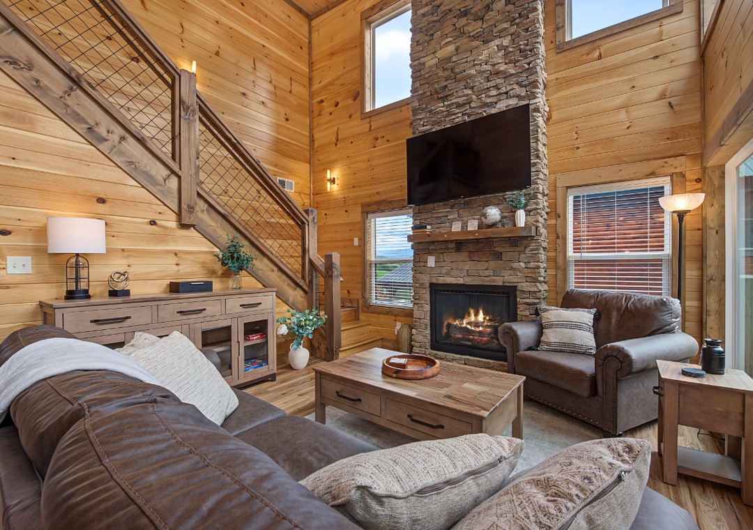 Sink into plush leather sofas by the stone fireplace, where natural wood walls and soaring ceilings create your perfect mountain retreat for cozy evenings.
