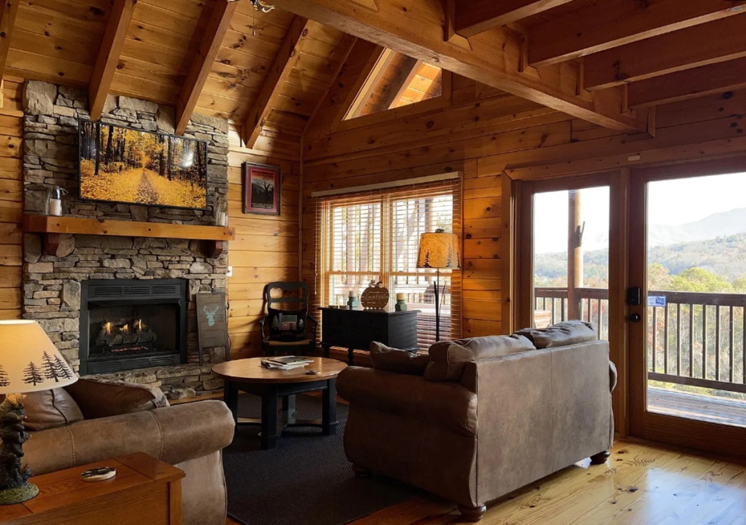 Imagine curling up in this cozy mountain retreat, where warm wood beams frame your view of rolling hills and autumn colors. The stone fireplace invites you to unwind after a day of adventure.