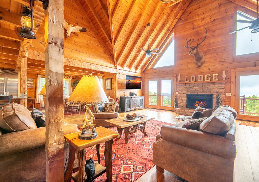 Step into your rustic mountain retreat where soaring timber ceilings and a cozy stone fireplace create the perfect lodge ambiance for your getaway.