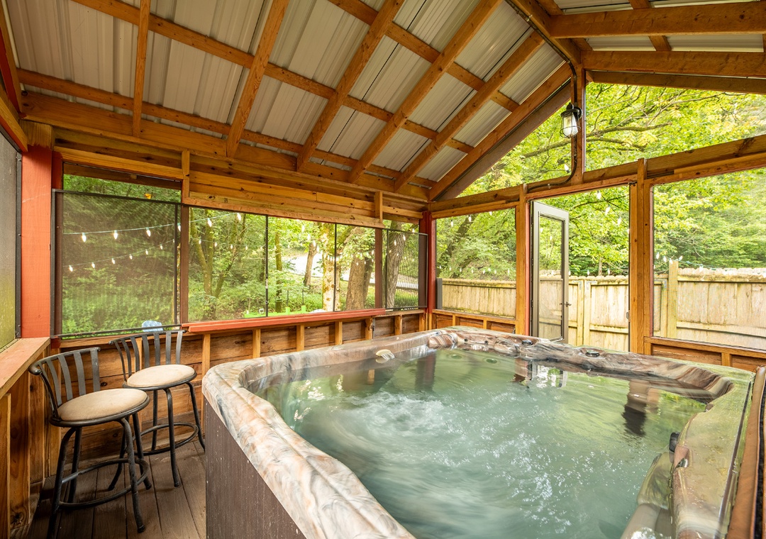 Sink into your private hot tub surrounded by lush greenery, where warm bubbles and forest views melt away everyday stress in this peaceful screened retreat.