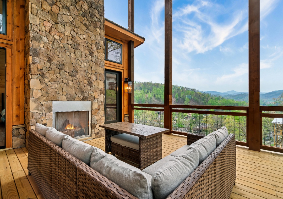 Relax by your private fireplace on this stunning mountain-view deck, where cozy seating meets breathtaking forest vistas.