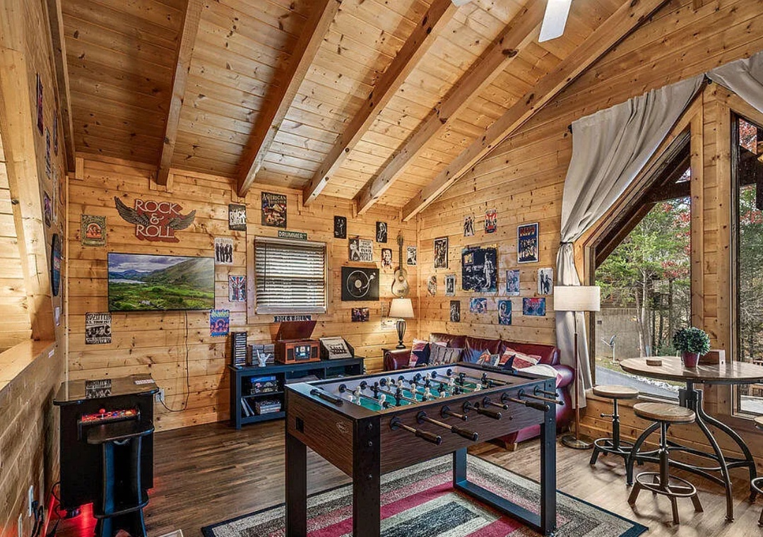 Your game loft awaits with foosball, arcade fun, and cozy seating surrounded by warm wood beams and rock memorabilia.