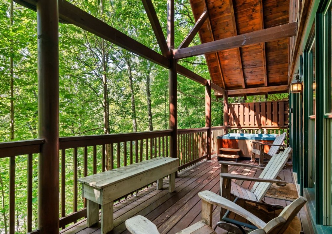Unwind on your private deck surrounded by lush forest canopy, complete with hot tub and rustic seating for peaceful forest retreat moments.