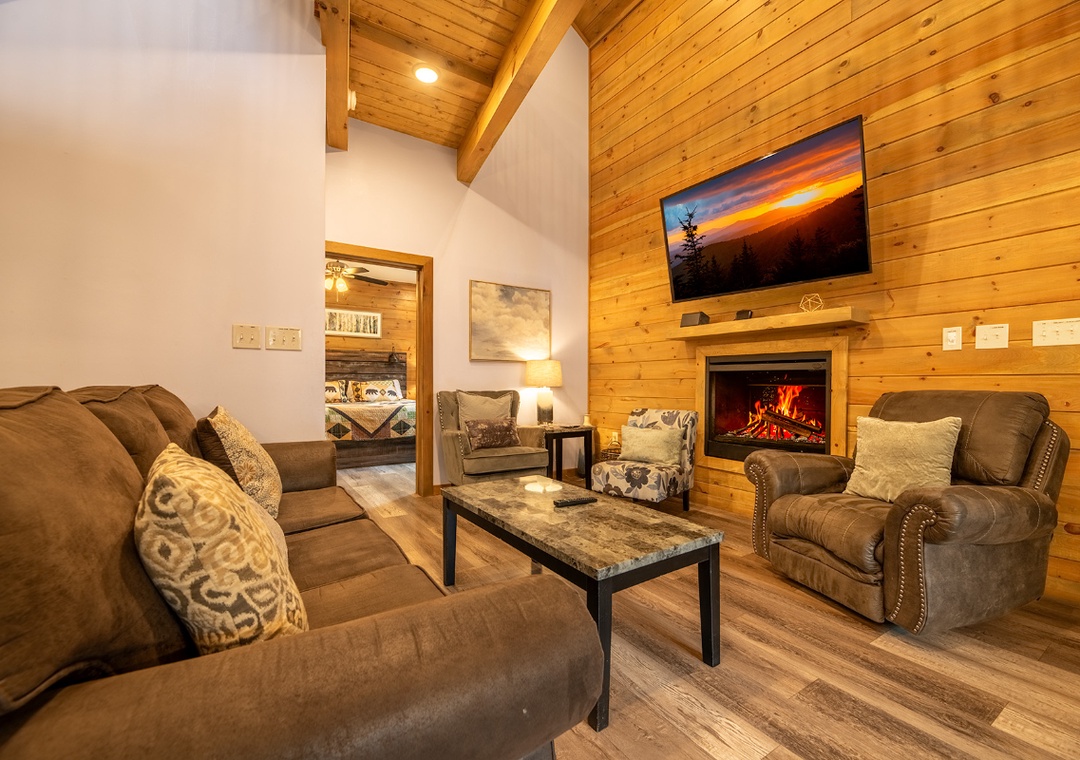 Picture yourself unwinding here after a day of adventure—plush seating, glowing fireplace, and a flat-screen TV create your perfect retreat.