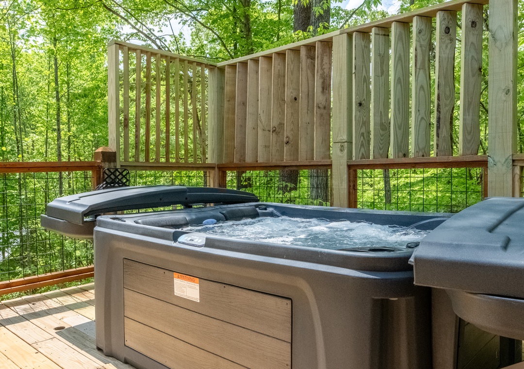 Soak away your cares in this private hot tub on your secluded deck, surrounded by lush forest canopy—your perfect spot to unwind under the trees.