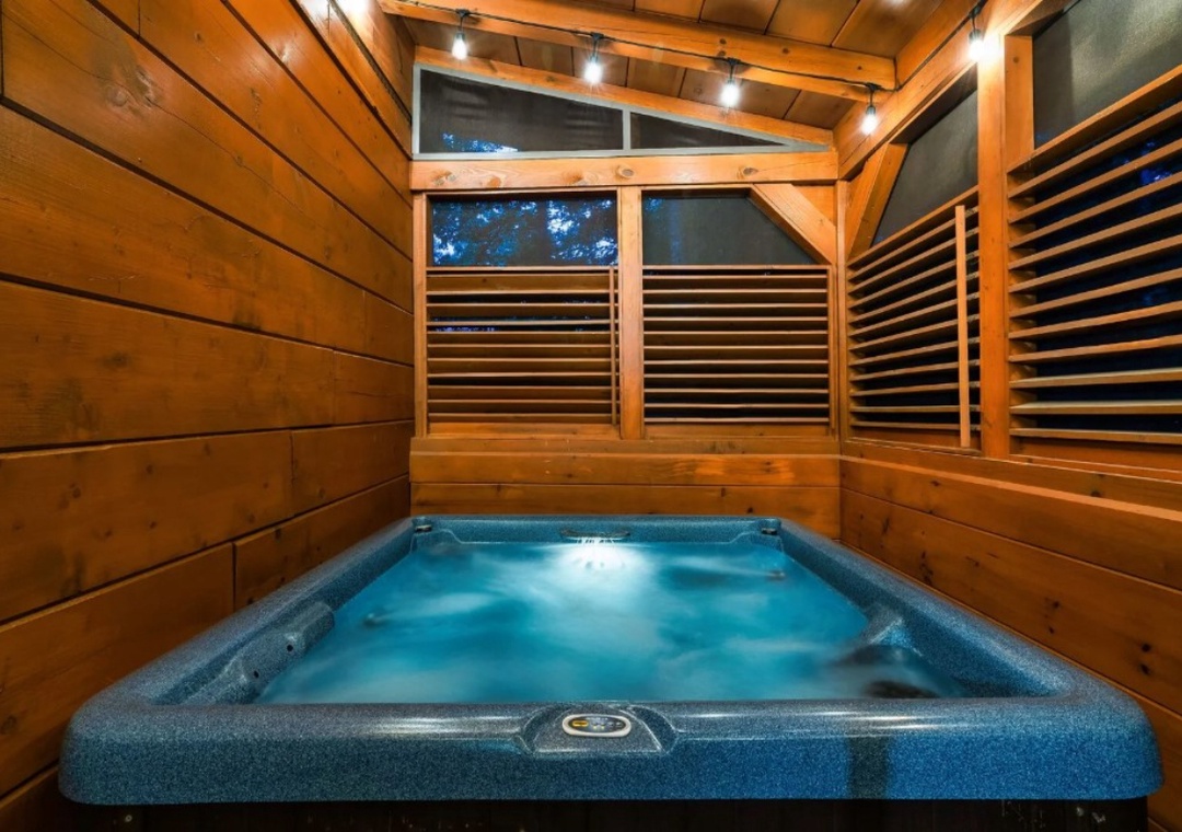 Soak away your stress in your private hot tub, surrounded by warm wood walls and gentle evening lighting.