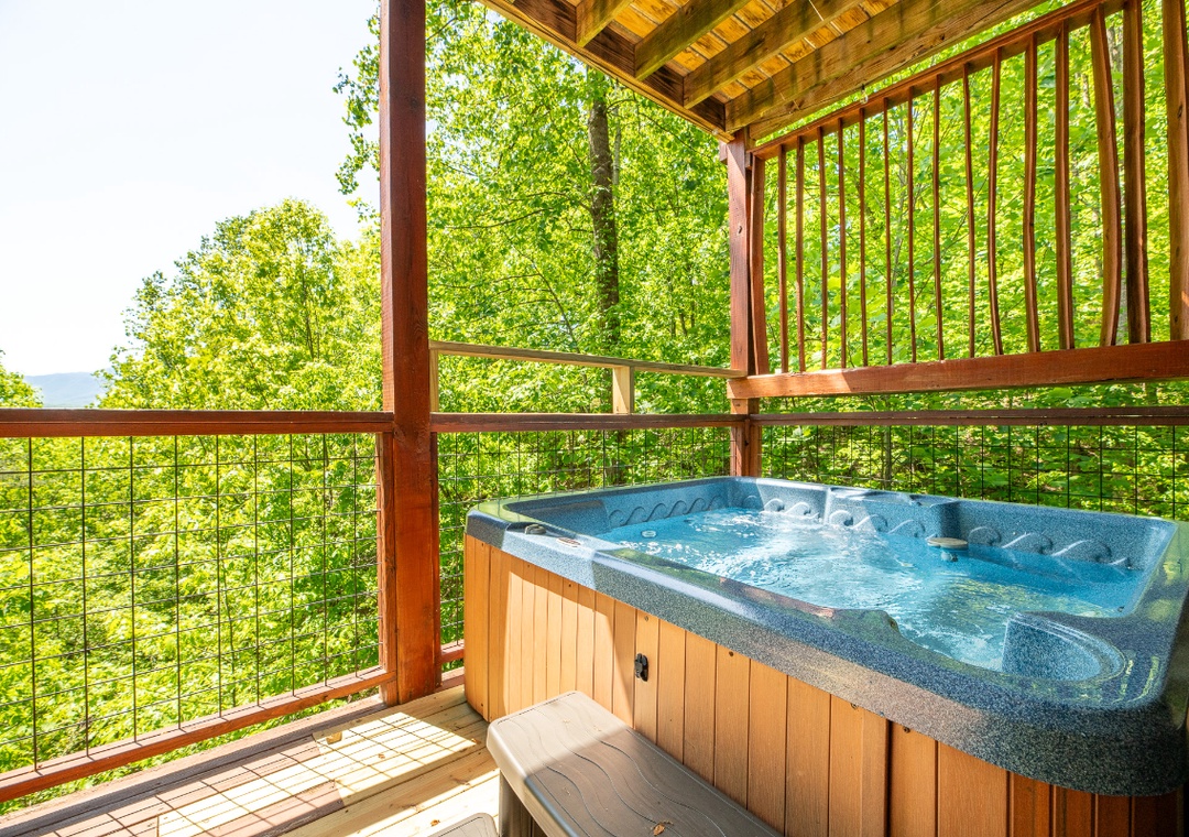 Soak in your bubbling hot tub while surrounded by vibrant green forest canopy—pure tranquility awaits on your covered deck.