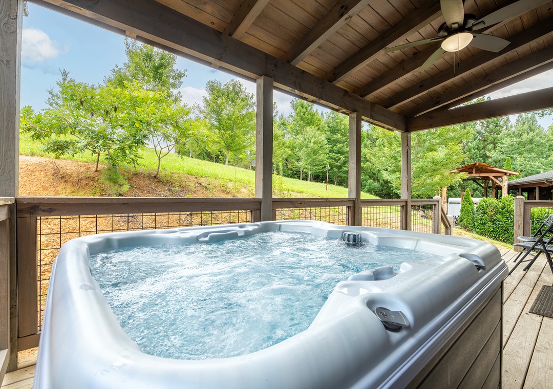 Soak your cares away in this spacious hot tub under a covered porch, surrounded by peaceful hillside greenery and fresh mountain air.