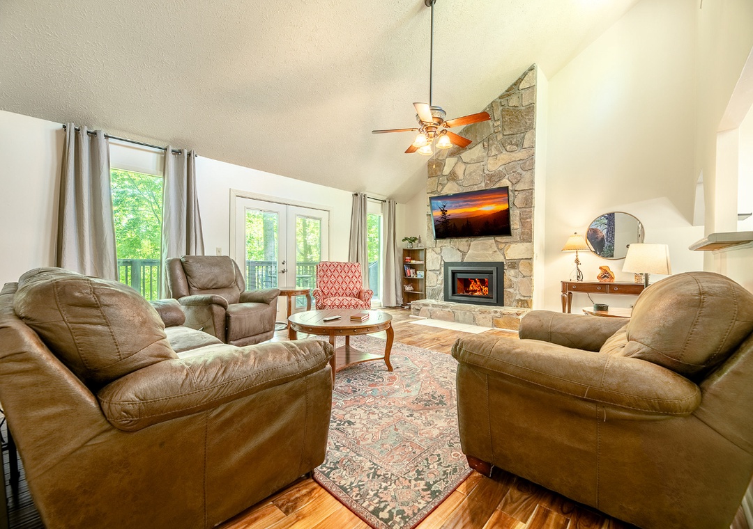 Sink into plush leather chairs by your crackling fireplace, where mountain sunsets on the big screen enhance cozy evenings in this inviting retreat.