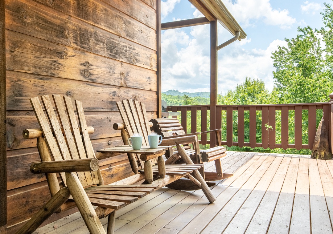 Unwind in handcrafted wooden chairs on your private deck overlooking lush mountain scenery—a peaceful retreat where morning coffee tastes even better with nature as your backdrop.