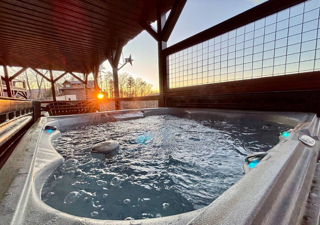 A covered hot tub awaits on the terrace, with golden sunrise views filtering through the wooden structure—perfect for relaxing mornings in the open air.