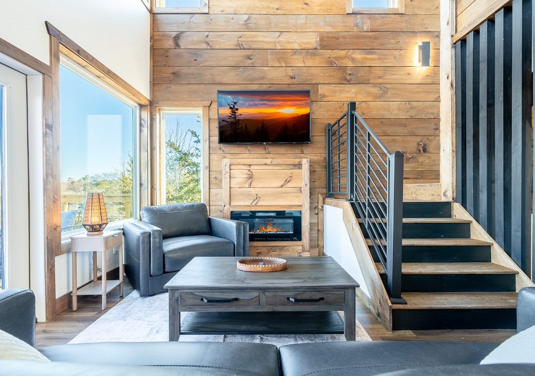 Unwind in your modern living space with cozy fireplace, sleek furnishings, and stunning views through floor-to-ceiling windows.