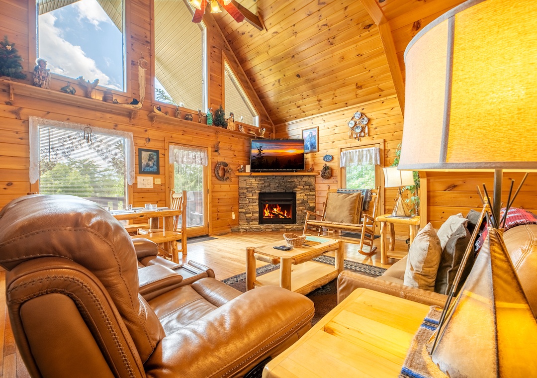 Step into your cozy cabin retreat where natural wood and warm lighting wrap around plush leather seating. Curl up by the stone fireplace or unwind in your inviting open-concept space.