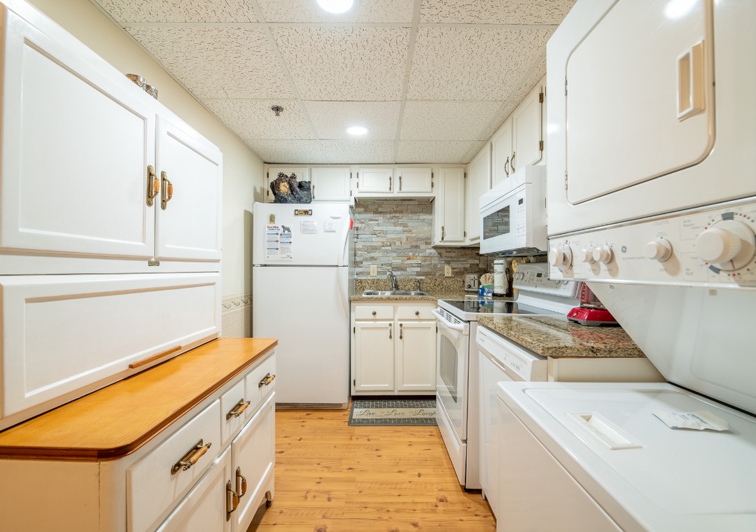 Your galley kitchen is fully equipped with ample counter space, modern appliances, and warm wood floors—perfect for whipping up home-cooked meals during your stay.