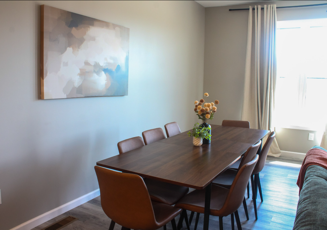 Gather around this elegant dining table where shared meals become cherished memories. Natural light fills the space, creating a welcoming atmosphere for your group to connect over breakfast or linger after dinner.