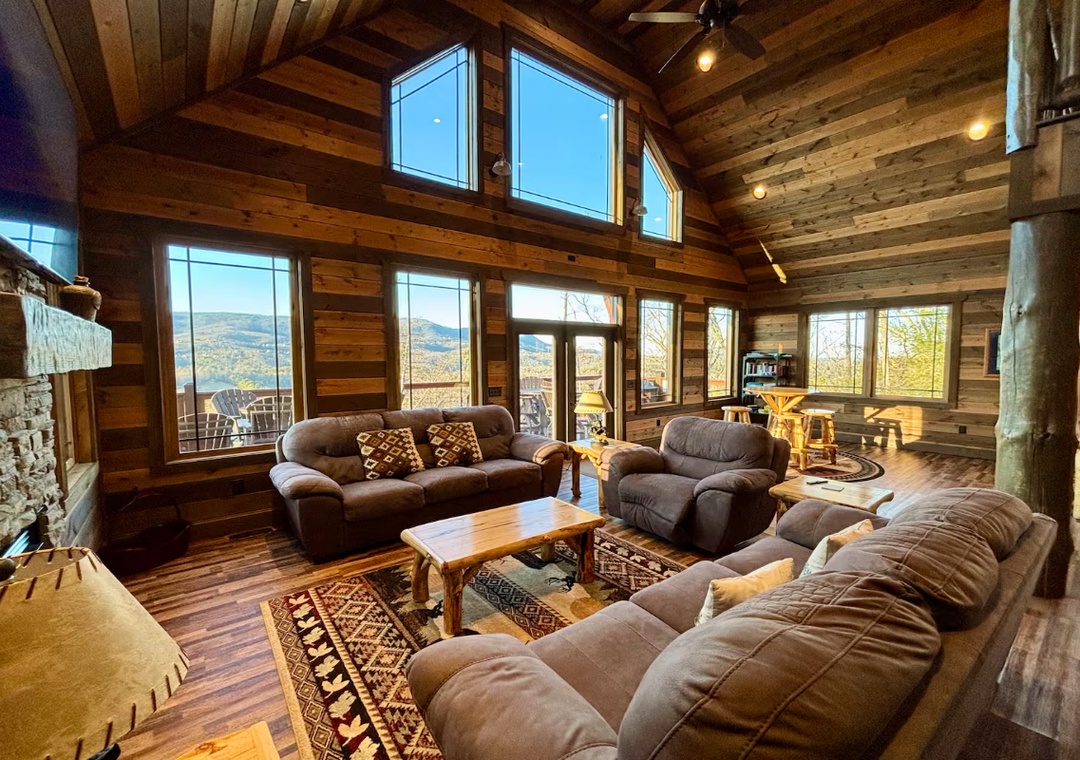 Unwind in your stunning mountain retreat with soaring vaulted ceilings, plush seating, and breathtaking panoramic views through floor-to-ceiling windows. Your peaceful escape awaits in this warm, rustic haven.