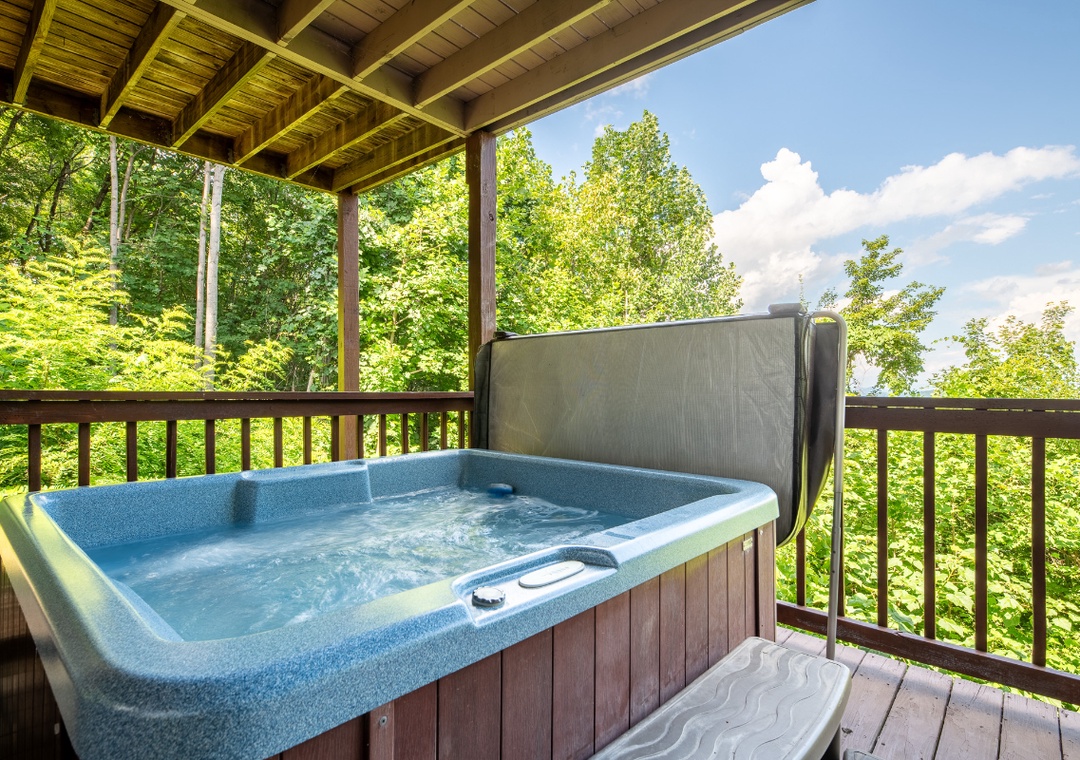Soak in your private hot tub on a covered deck surrounded by lush forest views—your perfect retreat after a day exploring the area.