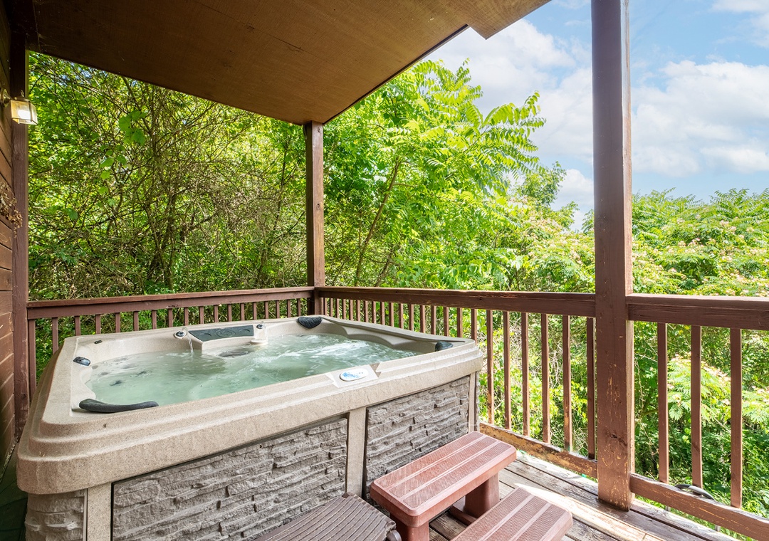 Soak in your private hot tub on the covered deck, surrounded by lush trees and fresh mountain air—perfect for unwinding after a day exploring nearby trails.