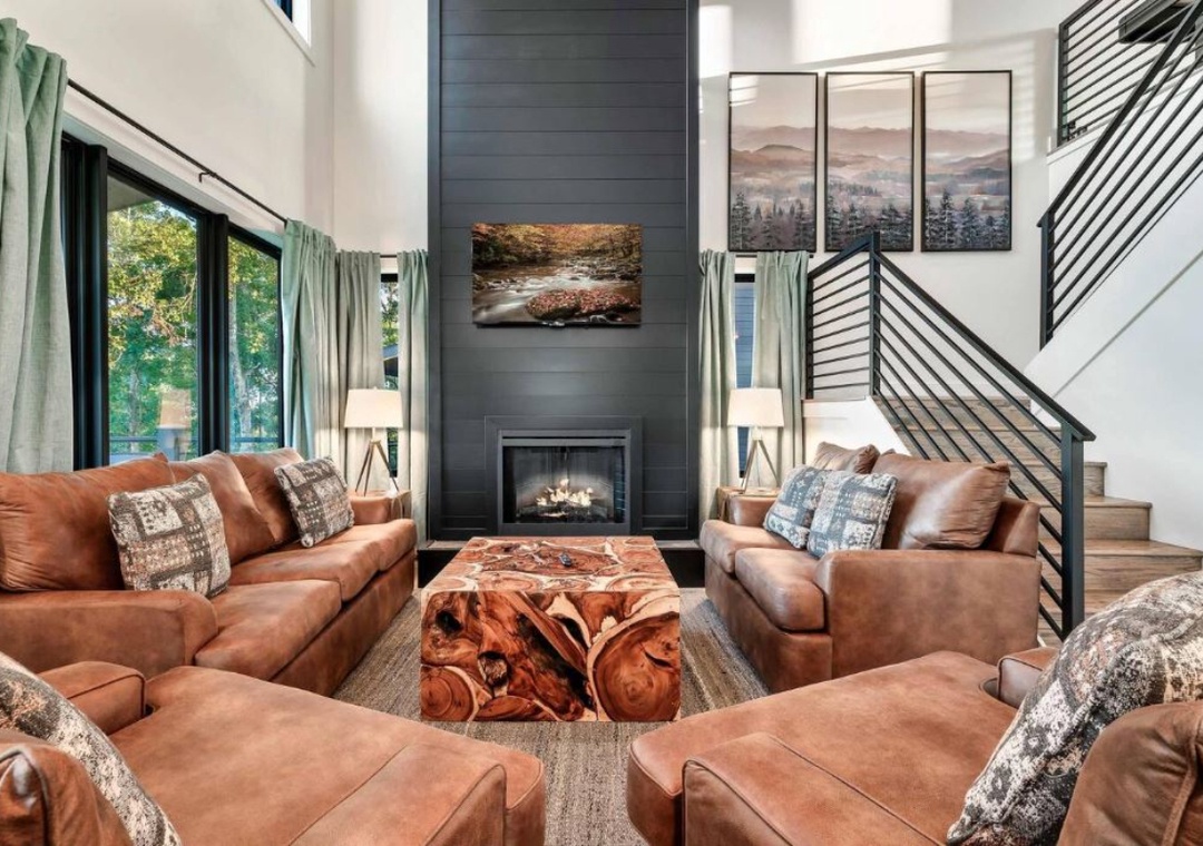 Sink into plush leather sofas by your crackling fireplace. Mountain views through expansive windows create the perfect backdrop for cozy evenings.