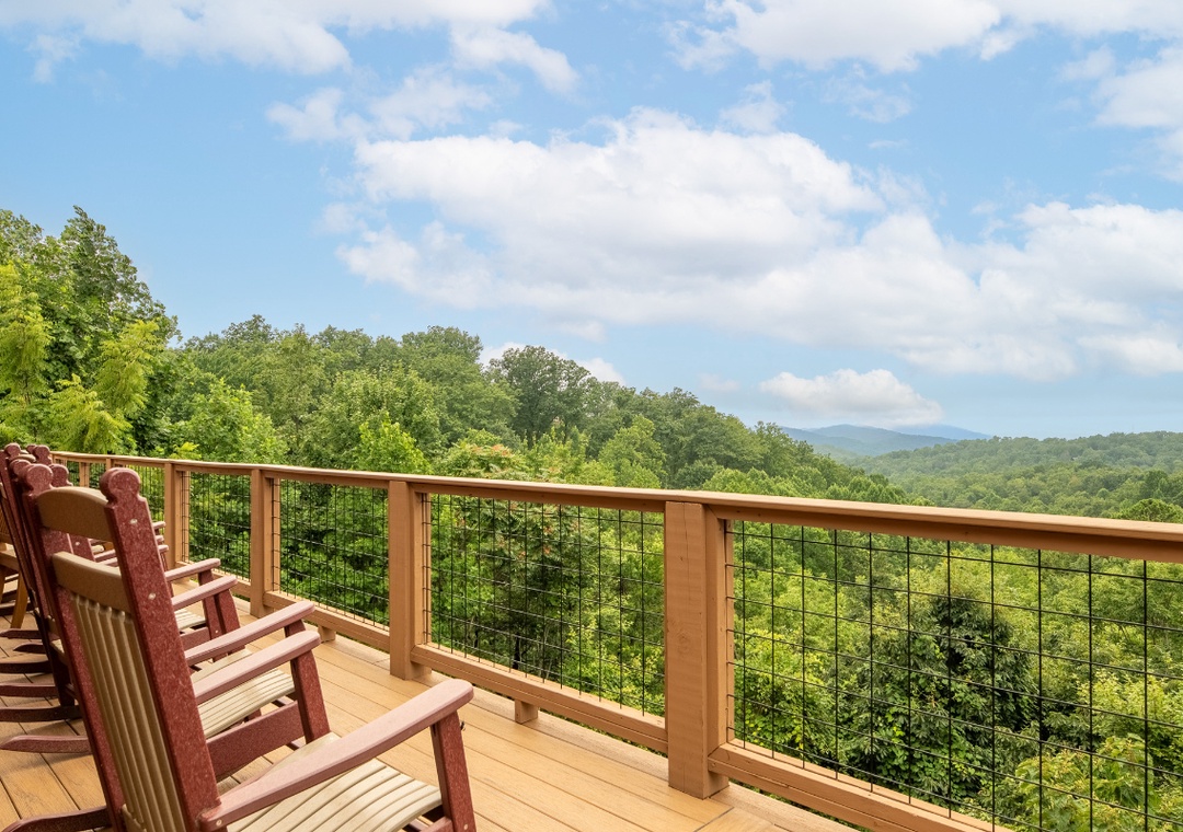 Sweeping mountain vistas stretch before you from this spacious deck, where classic Adirondack chairs invite quiet mornings and peaceful sunsets amid the fresh forest air.