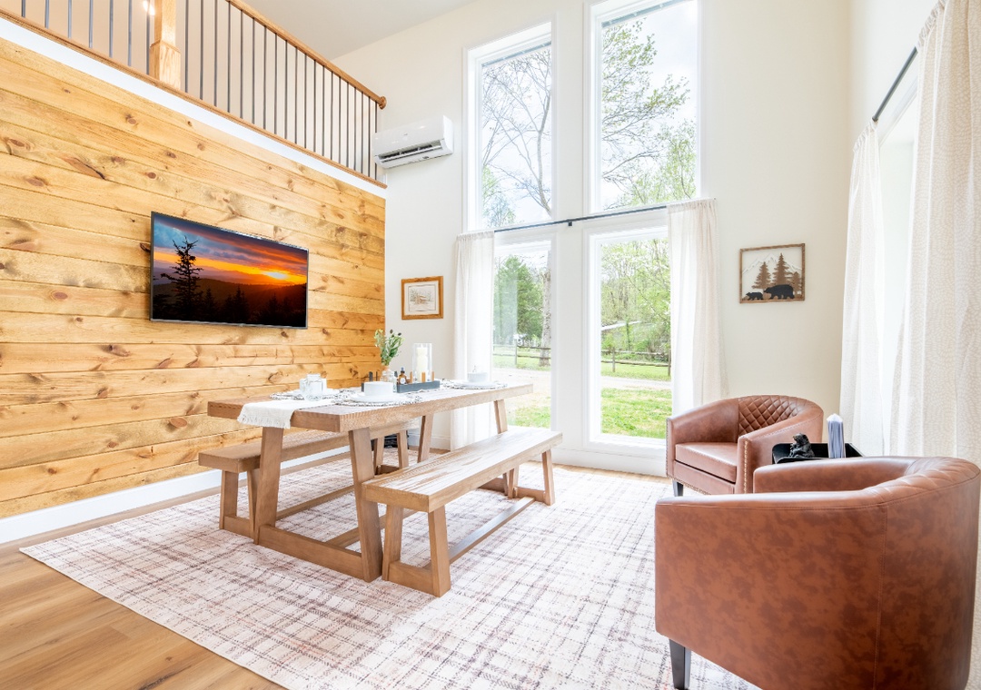 Relax in your bright living/dining space with warm wood accents, comfortable leather seating, and peaceful views.