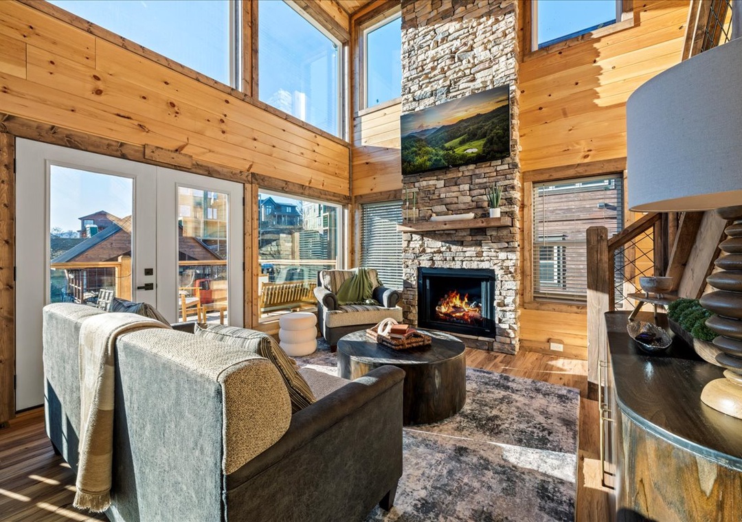 Sink into plush seating by your crackling fireplace, surrounded by soaring timber beams and panoramic windows that flood this stunning space with natural light.