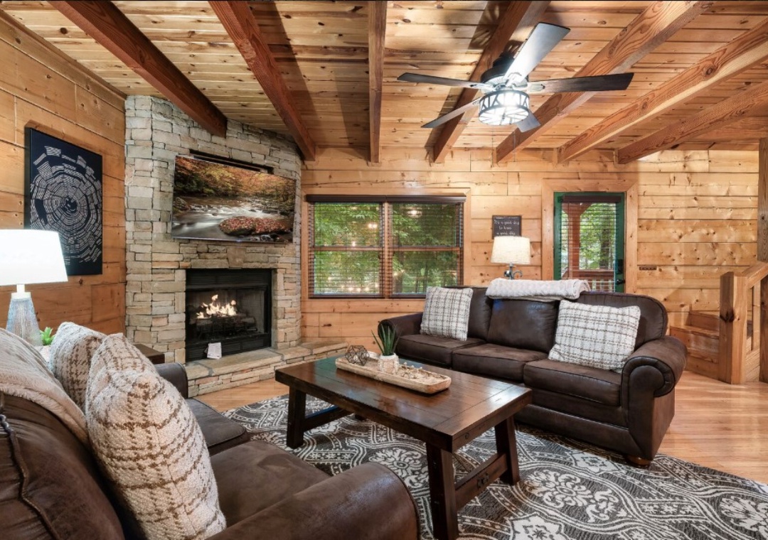 Sink into plush leather sofas by your crackling stone fireplace, surrounded by warm wood beams and forest views through large windows.