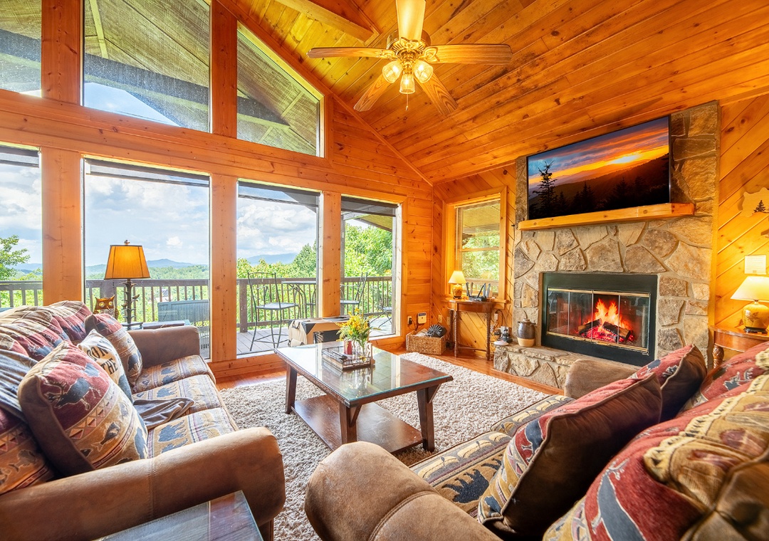 Relax in this warm living space with vaulted pine ceilings, a crackling stone fireplace, and sweeping mountain views—your perfect retreat after a day of adventure.