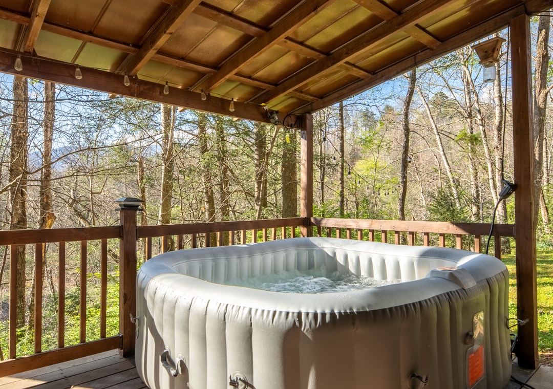Soak in your private hot tub while surrounded by peaceful woodland views from this covered deck sanctuary.