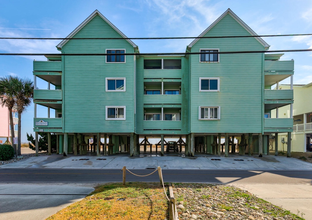 Charming turquoise beachfront building on stilts with multiple levels and ocean proximity, featuring coastal architecture design.
