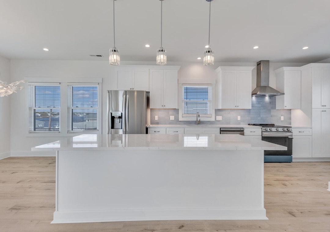 Cook and gather in this stunning modern kitchen with gleaming quartz counters, stainless steel appliances, and an expansive island perfect for your culinary adventures.