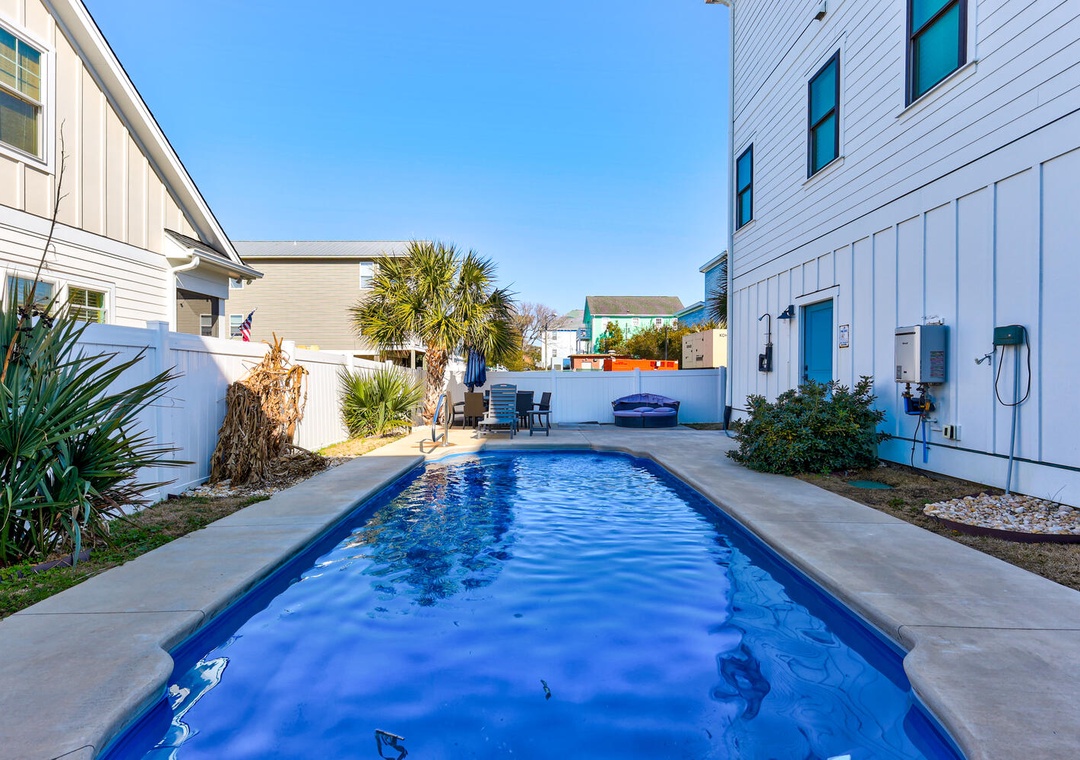 Your private oasis awaits with this sparkling blue pool surrounded by tropical landscaping in a peaceful residential setting.