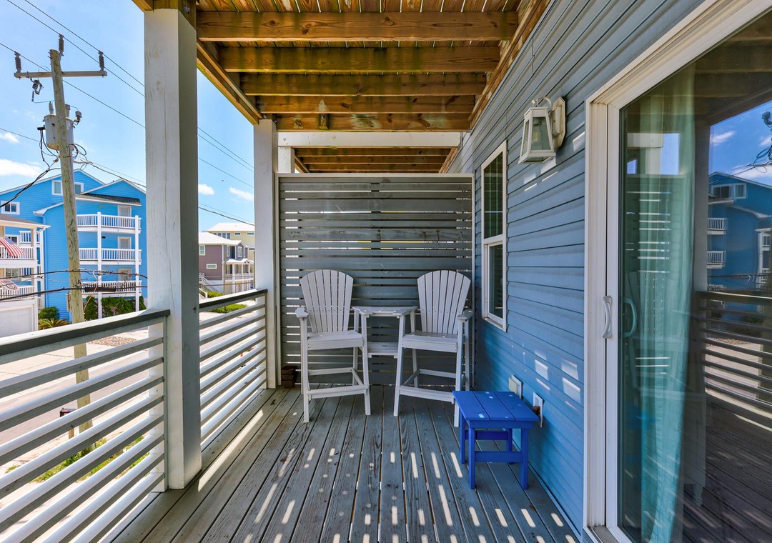 Step onto your private balcony and settle into cozy Adirondack chairs—perfect for morning coffee or watching the coastal town come to life around you.