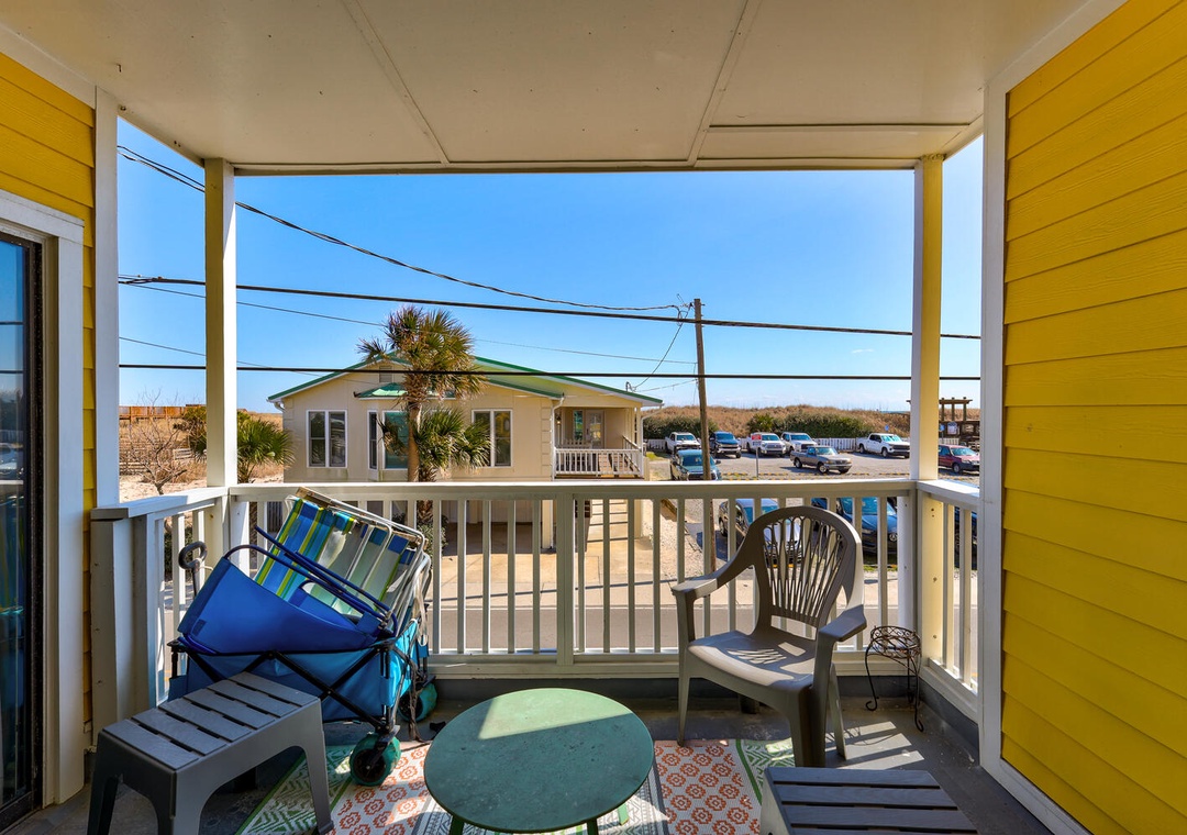Your private covered balcony offers comfortable seating and cheerful yellow accents, perfect for morning coffee or evening relaxation.