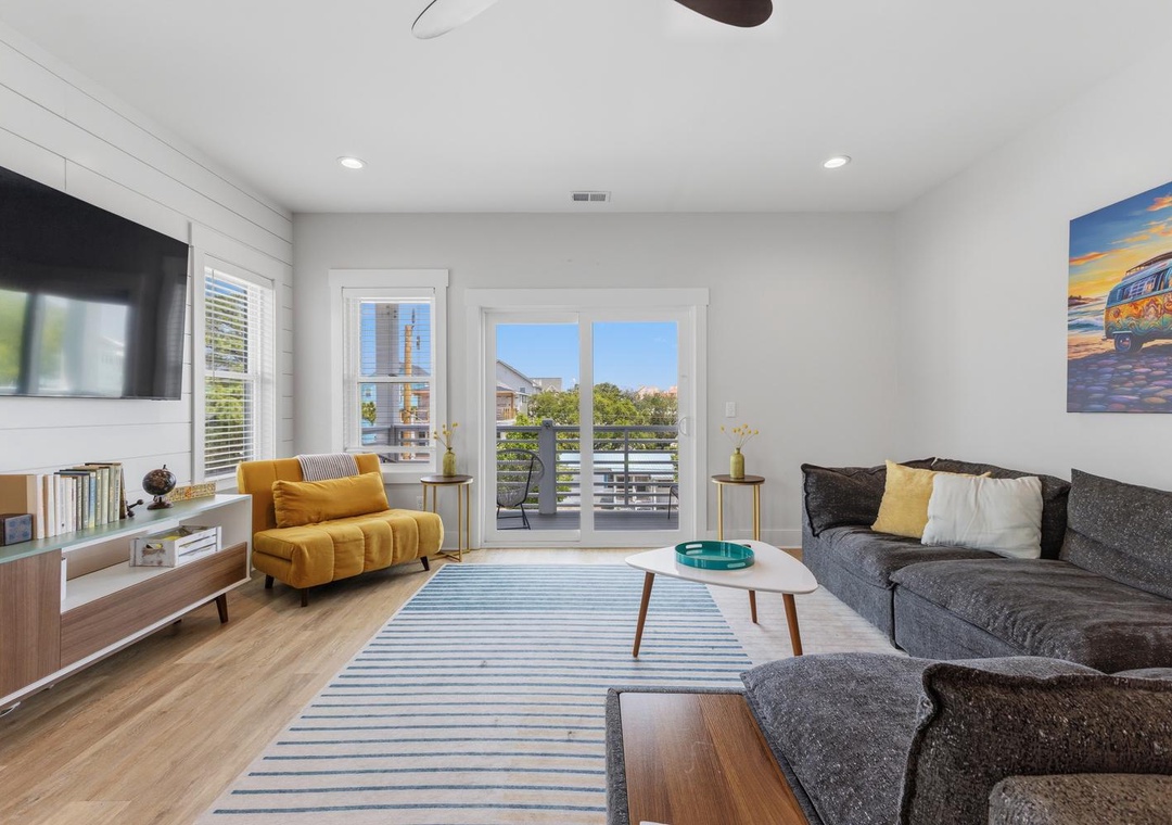 Unwind in this bright, stylish living room where plush seating and thoughtful accents await. Sunlight streams through balcony doors, inviting you to relax or step outside.