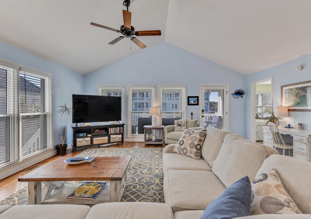 Sink into plush sofas in your bright living room, where coastal blue walls and natural light create the perfect setting for relaxation.