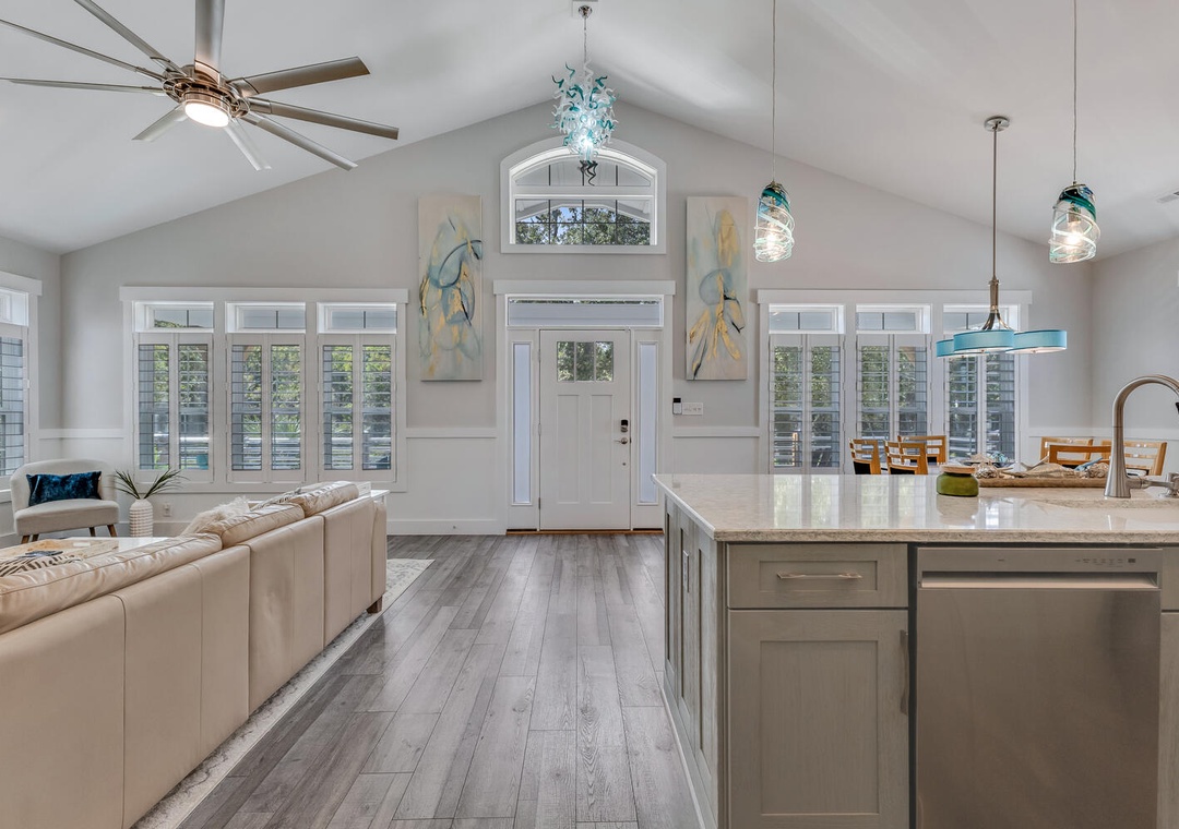Your bright open-plan living space features soaring vaulted ceilings, modern kitchen with marble countertops, and coastal-inspired décor perfect for gathering.