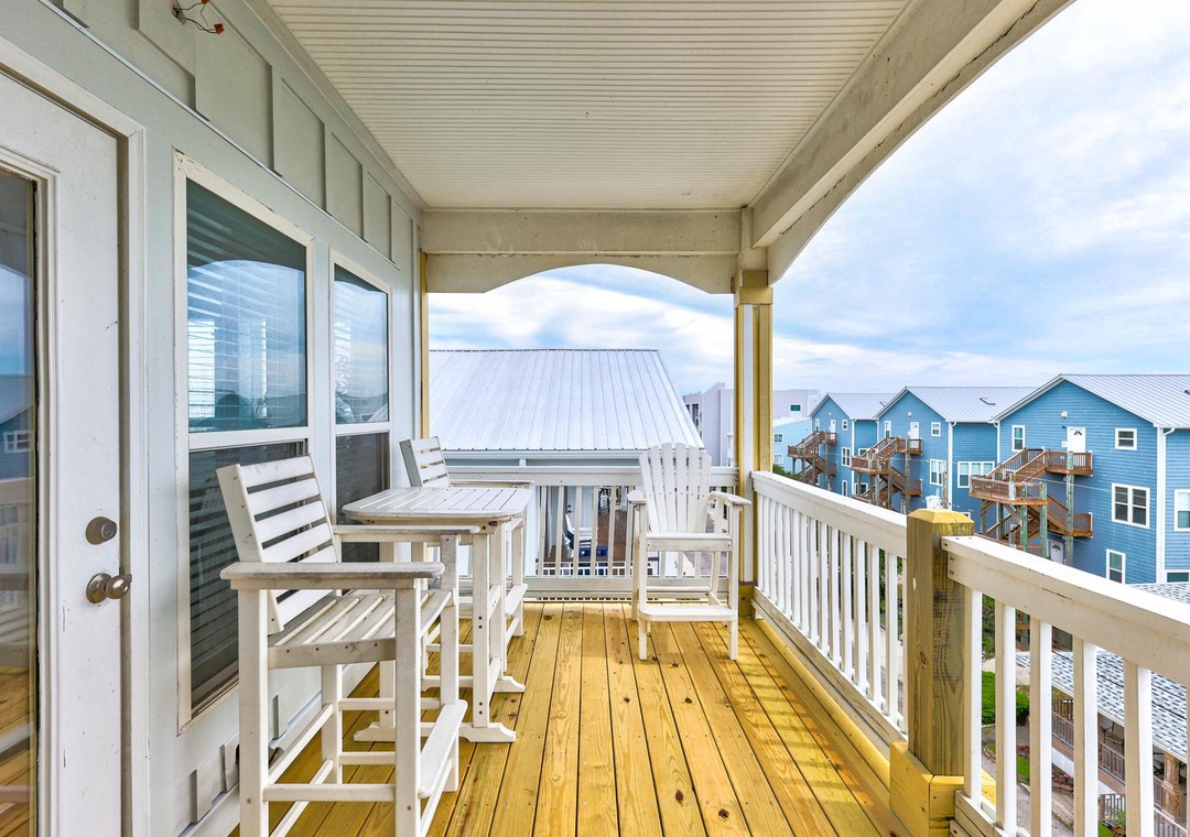 Step onto your private balcony and settle into rocking chairs with a table, perfect for morning coffee or evening wine while taking in views of the coastal community. The covered space invites you to relax rain or shine.