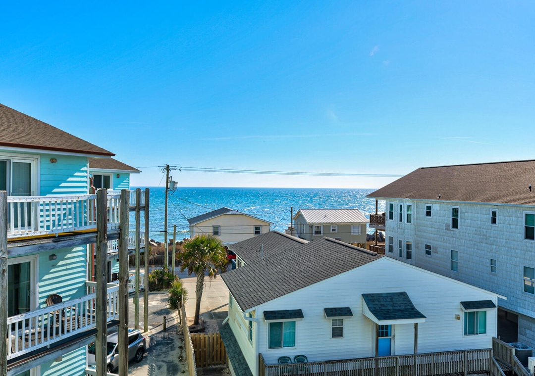 Coastal rental properties showcase colorful beach homes with ocean views and convenient beach access in a charming seaside community.