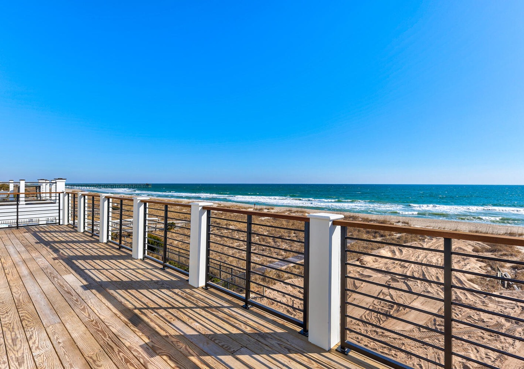 Ocean boardwalk with pristine sandy beaches stretching along the coastline under clear blue skies.