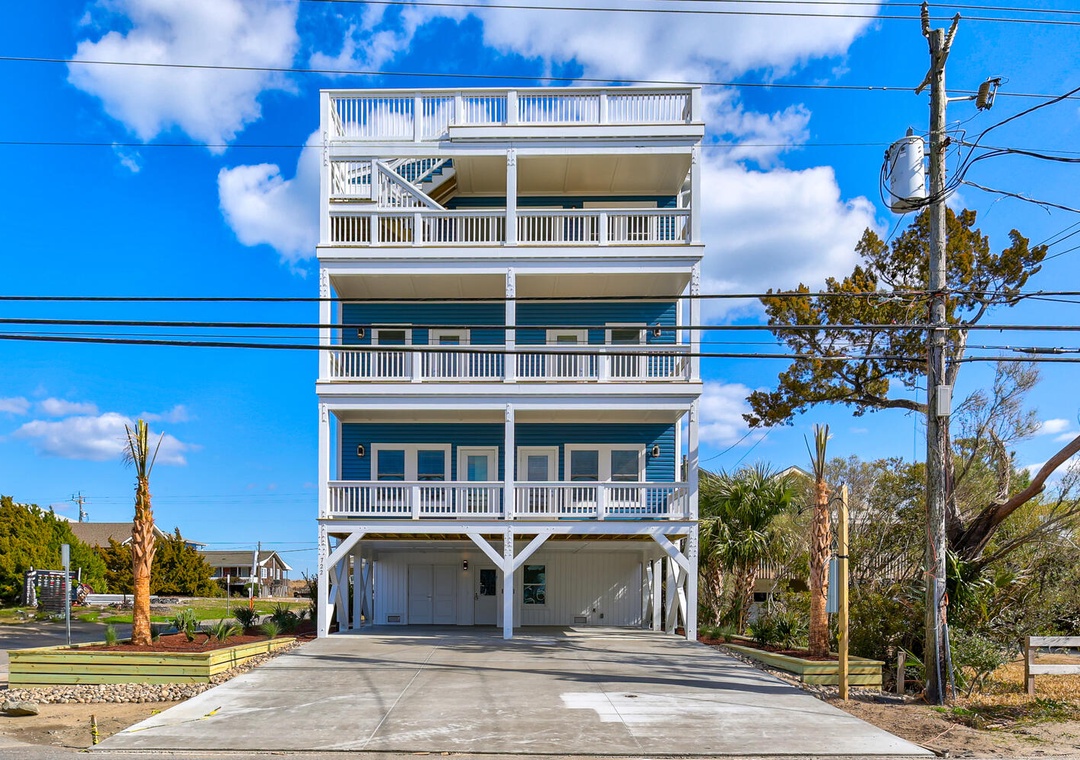 Modern coastal retreat with multiple levels of covered balconies and ground-level parking in a peaceful neighborhood setting.
