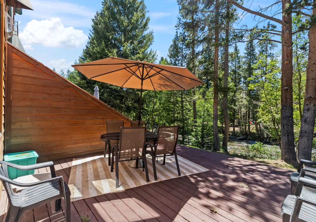 Unwind on your private deck surrounded by towering pines and forest serenity, perfect for sunny morning coffee or evenings under the umbrella's shade.