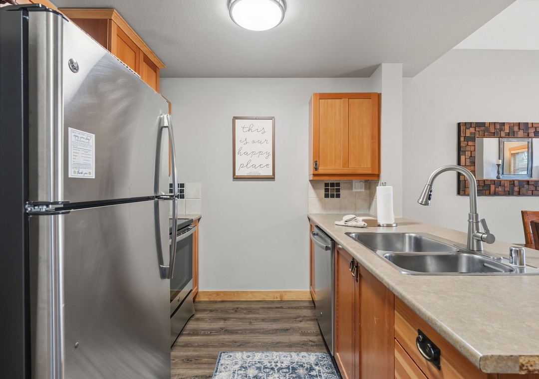 Step into your fully equipped kitchen where preparing meals is a breeze. Stainless appliances, ample counter space, and warm wood cabinetry create a welcoming spot to cook and gather.