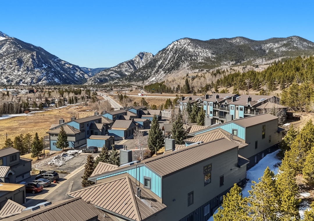 Mountain resort community nestled in a stunning valley with snow-capped peaks and pristine wilderness backdrop.