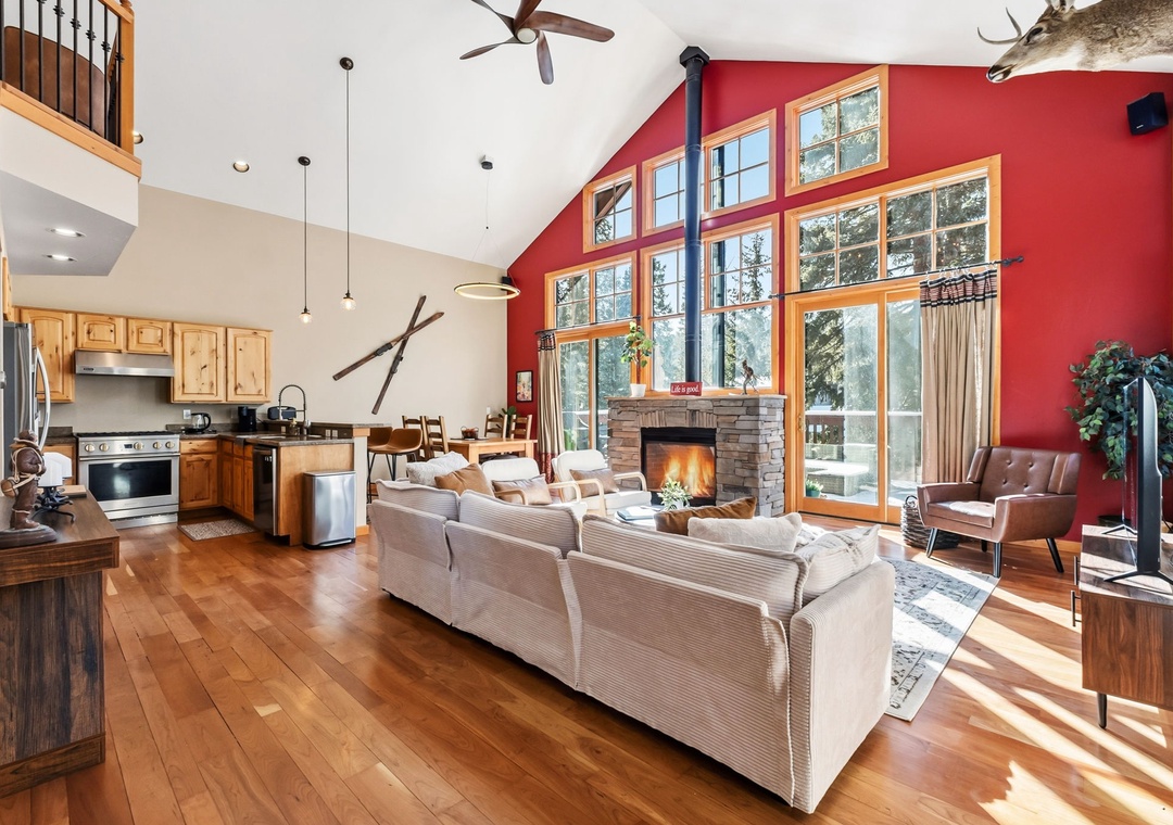 Relax in your spacious living area with soaring ceilings, crackling fireplace, and panoramic forest views through floor-to-ceiling windows.