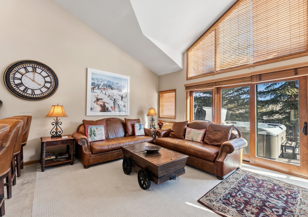 Relax in your spacious living room with rich leather seating and mountain views through large windows.