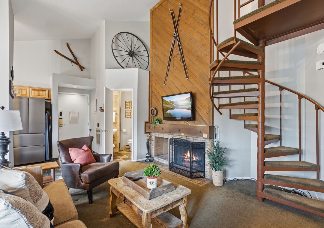 Relax in your inviting mountain retreat, where a crackling fireplace meets rustic charm. Curl up in the plush leather chair or sink into the sofa as you unwind beneath soaring vaulted ceilings and vintage ski-inspired décor.